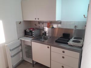 a small kitchen with a sink and a microwave at Appartamento Elisabetta in Gordola