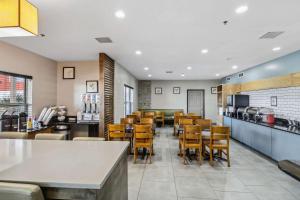 a restaurant with a bar and tables and chairs at Country Inn & Suites by Radisson, Chicago O Hare Airport in Bensenville