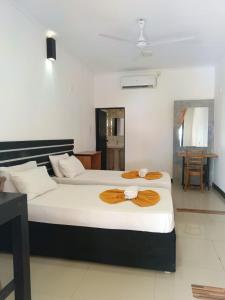 2 Betten in einem Hotelzimmer mit Handtüchern darauf in der Unterkunft Yes Beach House in Mirissa