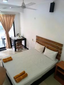 Schlafzimmer mit einem Bett, einem Tisch und einem Fenster in der Unterkunft Yes Beach House in Mirissa