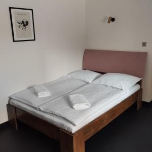 un letto con lenzuola e cuscini bianchi di Pod Domem a Grodzisk Mazowiecki