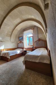 two beds in a room with an archway at Hotel Kral Boutique in Ürgüp