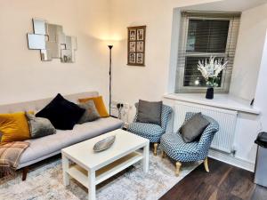 ein Wohnzimmer mit einem Sofa, 2 Stühlen und einem Tisch in der Unterkunft Theodora Suite 3 - Free Parking in Kent
