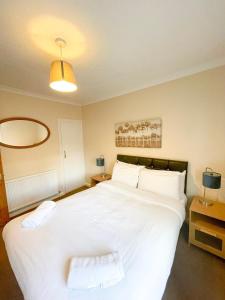 een slaapkamer met een groot wit bed met 2 kussens bij Sittingbourne Terrace in Sittingbourne