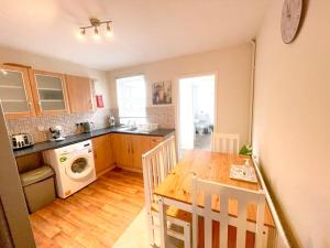 a kitchen with a wooden table and a dining room at Sittingbourne Terrace in Sittingbourne
