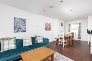 uma sala de estar com um sofá azul e uma mesa em Sunny Terrace By Kasar Stays em Maidstone