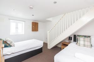 a bedroom with two beds and a staircase at Sunny Terrace By Kasar Stays in Maidstone