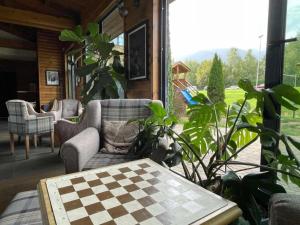 un porche cubierto con mesa y sillas a cuadros en Charming comfortable apartment at Cornelia Deluxe Residence with free pool and SPA, en Razlog