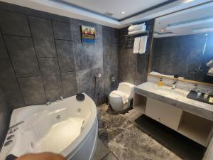 a bathroom with a tub and a toilet and a sink at Grace Cox Smart Hotel in Cox's Bazar