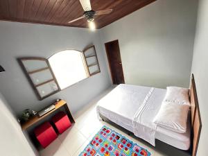 um quarto com uma cama, uma janela e um tapete em LaVille - Suítes em São Sebastião
