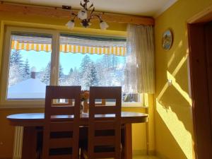 a dining room table and two chairs in front of a window at Apartment Tarman in Jesenice