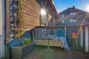 a patio with a couch on a wooden deck at Cozy 2-Bedroom Apartment - Free Parking in Haugesund