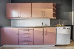 een keuken met roze kasten en een vaatwasser bij Cozy 2-Bedroom Apartment - Free Parking in Haugesund