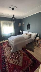 a bedroom with a bed with a rug and a window at Cozy 2-Bedroom Apartment - Free Parking in Haugesund