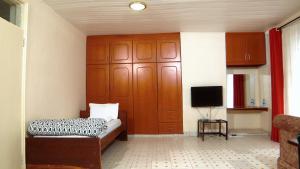 Zimmer mit einem Bett und einem TV. in der Unterkunft Kisumu Boutique Hotel in Maragoli