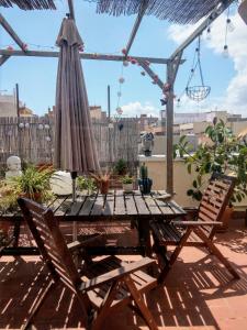 ein Terrassentisch mit Sonnenschirm und zwei Stühlen in der Unterkunft Atico Soleado in Esplugues de Llobregat + 11 Fotos