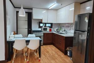 a kitchen with a refrigerator and a table with chairs at Pyeongtaek Tarot 2 House Camp Humphreys 워킹게이트 도보10분 in Pyeongtaek +10 photos