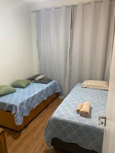 two twin beds in a room with white walls at Quinto do Tijuco in Diamantina