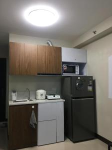 a kitchen with a black refrigerator and a microwave at NJC Staycation in Suba +6 photos