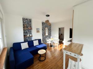 een woonkamer met een blauwe bank en een tafel bij Les appartements d'Ostende in Calais