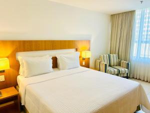 a hotel room with a large bed and a chair at Naoum Hotel in Brasília +15 photos