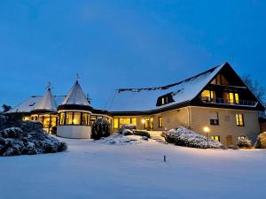 ein großes Haus im Schnee in der Nacht in der Unterkunft Landhotel Hubertus in Unterelsbach