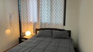 sypialnia z łóżkiem z oknem i lampką w obiekcie Atti w mieście Pyeongtaek