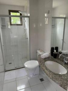ein Badezimmer mit Toilette, Waschbecken und Dusche in der Unterkunft Genipabu Club House Guarajuba Camaçari-Ba in Camaçari