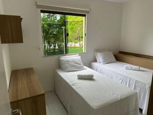 zwei Betten in einem Zimmer mit Fenster in der Unterkunft Genipabu Club House Guarajuba Camaçari-Ba in Camaçari + 78 Fotos