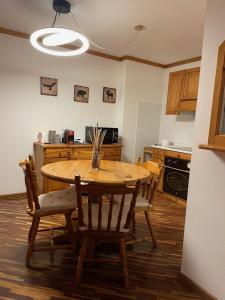 a kitchen with a wooden table and chairs in a room at Apartments Casa Metz in Santa Cristina in Val Gardena