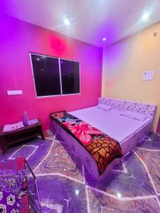 a bedroom with a bed in a room with pink walls at Parinay Vatika Inn in Deoghar