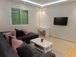 uma sala de estar com um sofá e uma televisão em Cozy sunny apartment em Salé