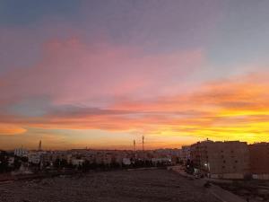 a view of a city with a sunset in the sky at Cozy sunny apartment in Salé