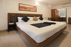 a bedroom with a large bed with white sheets at Amor Mystic Inn in Bangalore