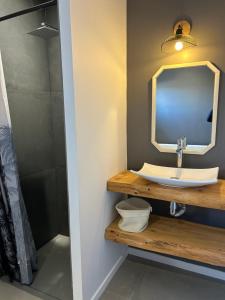 ein Badezimmer mit Waschbecken und Spiegel in der Unterkunft Villa contemporaine avec piscine in Magalas + 6 Fotos