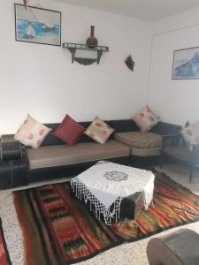 a living room with a couch with pillows and a rug at Dar arbi in Houmt Souk