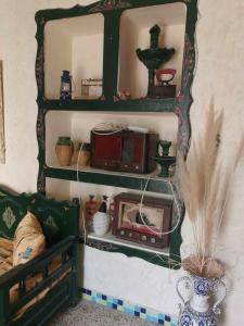 a shelf with a microwave and other items on it at Dar arbi in Houmt Souk