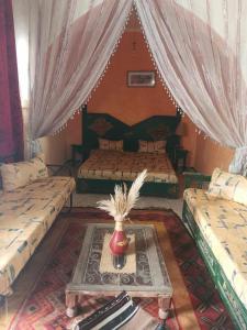 a bedroom with two beds and a table in a room at Dar arbi in Houmt Souk