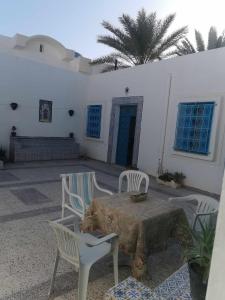 a patio with a table and chairs and a building at Dar arbi in Houmt Souk