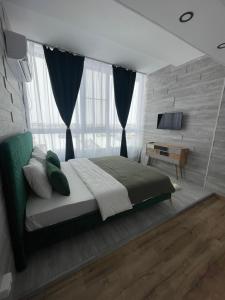 a bedroom with a large bed and a television at RDM Residence III in Otopeni