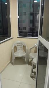 - une salle d'attente avec 2 chaises et une fenêtre dans l'établissement Condominio encantador em Parnamirim com Piscina, à Parnamirim