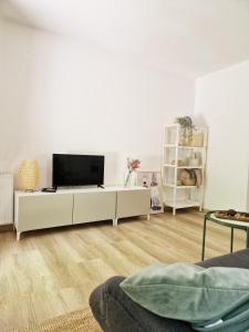 un salon avec une télévision à écran plat sur un mur blanc dans l'établissement Apartments Bassanese, à Bled