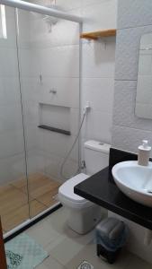 La salle de bains est pourvue d'une douche, de toilettes et d'un lavabo. dans l'établissement Condominio encantador em Parnamirim com Piscina, à Parnamirim