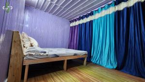 Cama en habitación con cortina colorida en Saatvik Space, en Shangarh