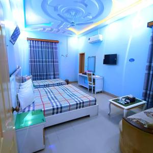 een slaapkamer met een bed en een tafel in een kamer bij Hotel Royal Star in Multan