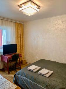 een slaapkamer met een bed en een bureau met een computer bij Apartament Ultraconfort in Iaşi