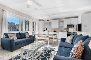 sala de estar con sofás azules y cocina en Destiny Beach Villas #11A&B- Beach Oasis, en Destin
