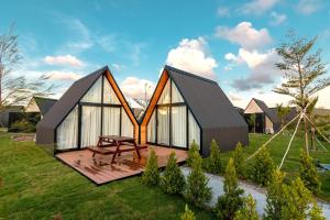 a small house with a wooden deck in a yard at Summer Bay Beach Club & Cabins in Sihanoukville