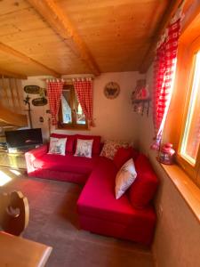 una sala de estar con sofás rojos en una cabaña en Cosy Chalet on Pokljuka - Brunarica Tinkara, en Zgornje Gorje