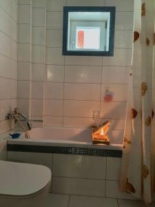 een badkamer met een bad, een toilet en een raam bij Apartament Ultraconfort in Iaşi